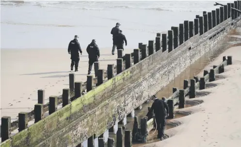  ??  ?? A police search team at work on Aberdeen beach where the two women were pulled from the sea by the RNLI