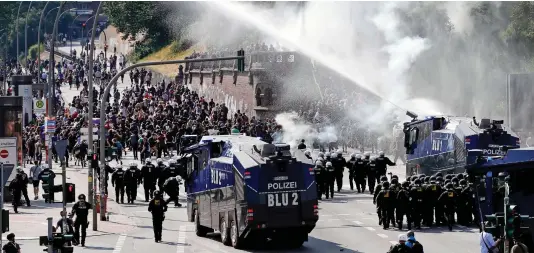  ??  ?? Mayhem: Police use water cannon on protesters attempting to disrupt the G20 summit in one of many clashes yesterday