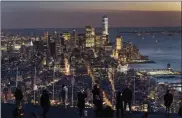  ??  ?? Visitors to the Edge, an outdoor observatio­n deck 1,100 feet above the ground, look at the lights of Manhattan on March 2 in New York.