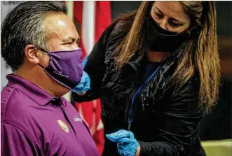  ??  ?? Erhardt Preitauer, president and chief executive of CareSource of Dayton, receives his second COVID-19 vaccine at the Dayton Convention Center on Thursday. The company is encouragin­g employees to get vaccinated.