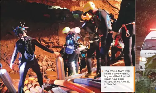  ?? AP ?? Thai rescue team walk ■ inside a cave where 12 boys and their football coach have been trapped since June 23, in Mae Sai