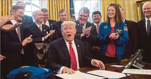  ?? PIC
AFP ?? President Donald Trump signing into law a bill to authorises funding for Nasa in the Oval Office at the White House in Washington on Tuesday.