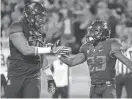  ?? CASEY SAPIO/USA TODAY SPORTS ?? Arizona running back J.J. Taylor (23) celebrates with offensive lineman Layth Friekh (58) after scoring a touchdown against Washington in Tucson last season.