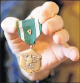  ??  ?? The “V” on the medal recognizes heroism in combat.