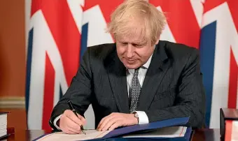  ?? AP ?? Britain’s Prime Minister Boris Johnson signs the EU-UK Trade and Co-operation Agreement.