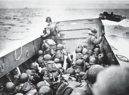  ?? COLLECTION/U.S. NATIONAL ARCHIVES U.S. COAST GUARD ?? Troops crouch inside a LCVP landing craft, just before landing on Omaha Beach on D-day, 6 June 1944.