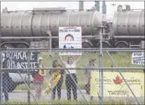  ?? CP PHOTO ?? Protestors stand outside the fence as Prime Minister Justin Trudeau visits Kinder Morgan in Edmonton Alta., on June 5.