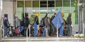  ?? RICARDO B. BRAZZIELL / AMERICAN-STATESMAN ?? A group of people wait in line Tuesday outside the Austin Resource Center for the Homeless in downtown Austin, seeking shelter.