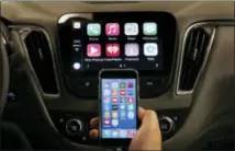  ?? PAUL SANCYA — THE ASSOCIATED PRESS ?? In this file photo, an iPhone is connected to a 2016 Chevrolet Malibu equipped with Apple CarPlay apps, displayed on the car’s MyLink screen, top, during a demonstrat­ion in Detroit.