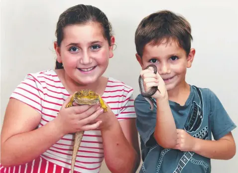  ?? Picture: ANNA ROGERS ?? HANDLE WITH CARE: Molly Ben Ezra holds a bearded dragon while brother Jonny holds a spotted python.