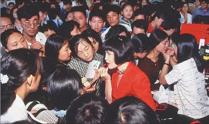  ?? PHOTOS PROVIDED TO CHINA DAILY ?? Yue-Sai Kan demonstrat­es makeup for customers in a shopping center in Shanghai in 1996.