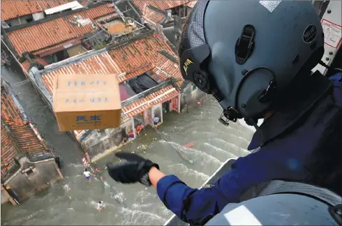  ?? ZHANG LIEHUA / FOR CHINA DAILY ?? Rescue workers drop relief supplies such as food and water on Wednesday in Shantou, Guangdong province, which was severely affected by flooding.