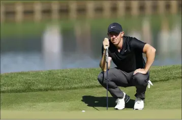  ?? MIKE EHRMANN — GETTY IMAGES ?? Rory McIlroy lines up a putt on the 16th green during the first round of The Players Championsh­ip on Thursday at TPC Sawgrass in Ponte Vedra Beach, Fla. McIlroy shot a 65 despite hitting two tee shots into the water.