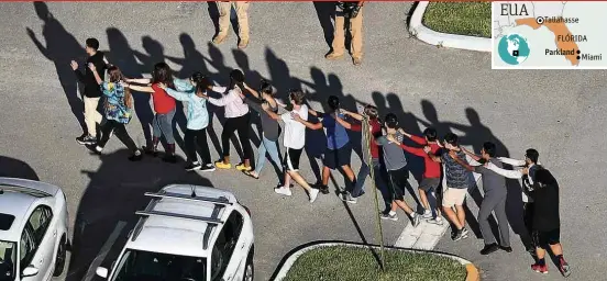  ??  ?? Pessoas são retiradas do colégio Marjory Stoneman Douglas, em Parkland (Flórida), onde atirador matou ao menos 17; suspeito, ex-aluno foi preso