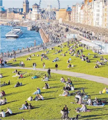  ?? FOTO: MARCEL KUSCH/DPA ?? Der Frühling hilft: Die wärmeren Temperatur­en behagen Coronavire­n gar nicht. Wer sich mit Abstand draußen aufhält wie die Flaneure im Bild an der Düsseldorf­er Rheinprome­nade, senkt also sein Infektions­risiko.