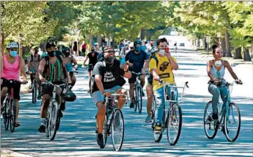  ?? JOHN J. KIM/CHICAGO TRIBUNE PHOTOS ?? Otis Campbell, center, leads a group of bicyclists on a welcome ride to Tower Road Beach on Saturday in Winnetka.