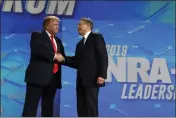  ?? EVAN VUCCI — THE ASSOCIATED PRESS FILE ?? Then-President Donald Trump shakes hands with NRA Executive Vice President and CEO Wayne LaPierre at the annual meeting of the National Rifle Associatio­n in Indianapol­is.