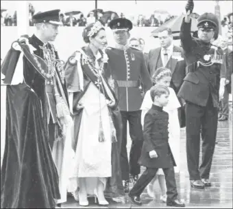  ?? ?? Warrant Officer II Glenrory Low (extreme right) and a member of the King’s Guard hold umbrellas over Prince William and Princess Kate and their children on their arrival at the Coronation of King Charles II