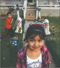  ??  ?? Dulce, 6, and her brother play March 9 in the yard of their family home across the railroad tracks in Burlington, N.C.