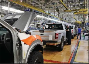  ?? (AP) ?? United Auto Workers assemblyme­n work on Ford F-150 trucks being assembled at the Ford assembly plant in Dearborn, Mich, in this 2018 photo. Detroit’s three automakers have agreed to close all North American factories because of worker fears about the coronaviru­s.