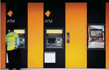  ??  ?? No effect: A man using a Commonweal­th Bank ATM in Sydney. The bank announced a board shake-up on Monday but the move failed to appease investors. — Reuters