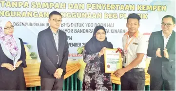  ??  ?? Noorliza (middle) presenting the certificat­e to one of 99 Speedmart’s representa­tives, together with Lim (second left) and Simon (right).