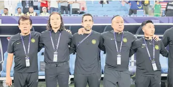  ?? — Bernama file photo ?? Pan Gon (second left) looks on during the national anthem prior to the start of a match.