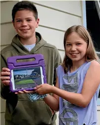  ?? CATHERINE GROENESTEI­N/STUFF ?? Connor, 12, and Hannah, 10, Barkla with a photo they took of the house fire at a neighbour’s property in Ha¯wera on Wednesday.