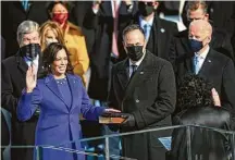  ?? Jonathan Newton / Washington Post ?? Vice President Kamala Harris takes the oath of office with her husband, Doug Emhoff, holding the Bible on Wednesday.