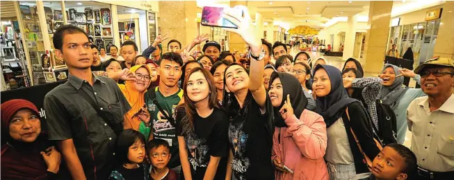  ?? AKHMAD RIZAL/JAWA POS ?? KESEMPATAN LANGKA: Cut Meyriska (kiri) dan Laura Theux saat selfie bersama para pengunjung Royal Plaza Surabaya yang akan menyaksika­n film terbaru mereka yang berjudul Jaran Goyang kemarin.