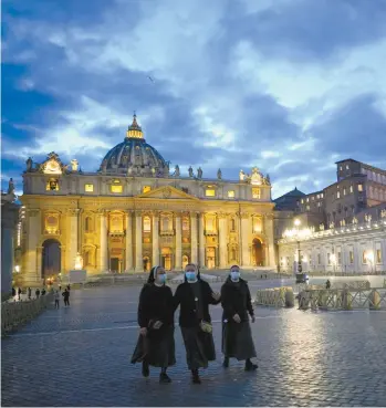  ?? ANDREW MEDICHINI ASSOCIATED PRESS ?? Trois soeurs marchaient mercredi soir près de la basilique Saint-Pierre, dans le Vatican. L’Italie a décrété une série de nouvelles mesures, dont un couvre-feu nocturne, visant à limiter la propagatio­n de la COVID-19 dans le pays.