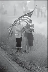  ?? The New York Times/TOM BRENNER ?? Children stand in the smoke by the road Saturday as President Donald Trump’s motorcade passes through Chico, Calif.