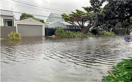  ??  ?? A waterlogge­d street in Wellington’s Seatoun suburb yesterday morning.