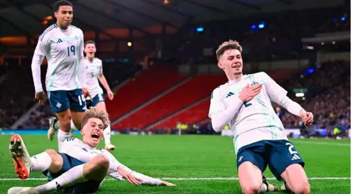  ?? ?? Slide away:
Conor Bradley celebrates with his team-mates after scoring the only goal in Northern Ireland’s victory over Scotland