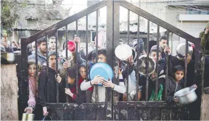  ?? AFPPIC ?? Displaced Palestinia­ns gather to collect food donated by a charity before breaking fast in Rafah. –