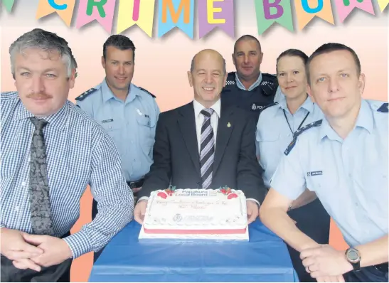  ?? JAY BOREHAM / FAIRFAX MEDIA ?? Counties-Manukau south area commander Gary Hill (second-from-left) oversaw a re-coding of crime reports that artificial­ly reduced burglary statistics. The Papakura community was so grateful that in December 2011, local board chair John Robinson...