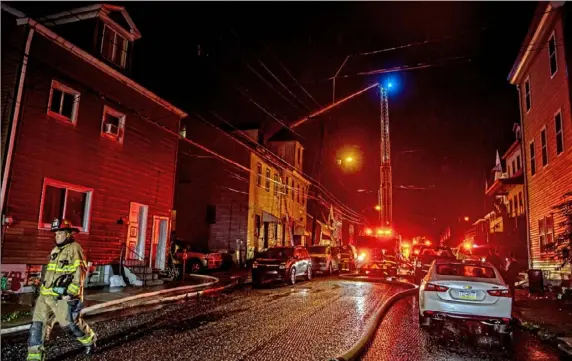  ?? Alexandra Wimley/ Post- Gazette ?? Firefighte­rs battle a building fire Sunday evening at 38 Mount Oliver Street in the South Side Slopes.