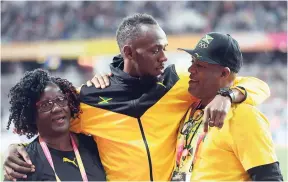  ?? PHOTO BY RICARDO MAKYN/MULTIMEDIA PHOTO EDITOR ?? Usain Bolt embraces his mother Jennifer Bolt and father Wellesley Bolt during his farewell ceremony at the recent IAAF World Championsh­ips in London.