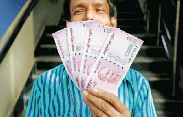  ?? R euters ?? ±
A man displays 2,000 Indian rupee banknotes after withdrawin­g them from a bank branch in Kolkata, India.
