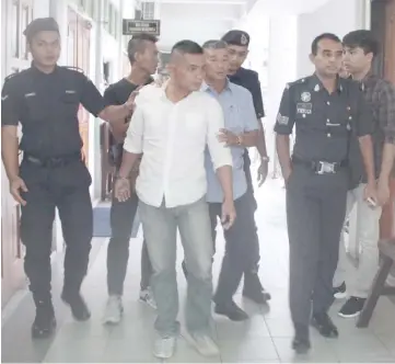  ??  ?? Mohd Nadzrin (front, centre) being led out of the courtroom after sentencing.