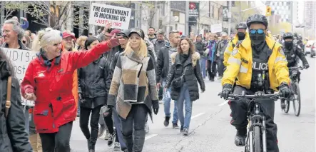  ?? CHRIS HELGREN • REUTERS ?? Police officers ride bikes as demonstrat­ors protest against new COVID-19 restrictio­ns in Toronto on Saturday.