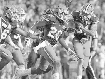  ?? PHELAN M. EBENHACK/ASSOCIATED PRESS ?? Florida defensive back Marcell Harris (26) is congratula­ted by teammates after an intercepti­on during the 2016 season.