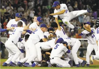  ?? Nati Harnik / Associated Press ?? Center fielder Nick Horvath (26) jumps into a pile of celebratin­g Gators after Florida defeated LSU in Game 2 of the finals to sweep the three-game series and win the NCAA championsh­ip.