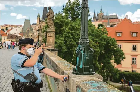  ?? Foto: Michal Turek, MAFRA ?? Dokumentac­e Policisté včera zdokumento­vali modré nápisy a čmáranice na zábradlí, lampě i podstavci jedné ze soch.