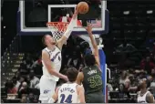  ?? JESS RAPFOGEL — THE ASSOCIATED PRESS ?? Washington Wizards center Kristaps Porzingis blocks a shot by Minnesota Timberwolv­es center Karl-Anthony Towns (32) during the first half Monday in Washington.