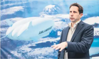  ?? Picture: AFP ?? FLOATING. Hybrid Air Vehicles chief executive officer Tom Grundy speaks about the company’s heium-filled aircraft in Bedford, England. Up to 100 passengers will be able to admire the landscape through panoramic windows on Airlander 10, an airship much slower than an airplane, but less polluting.