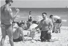  ?? BRITTANY WALLMAN/STAFF ?? Dennis Colley of the Fort Lauderdale beach patrol tells a group of spring breakers that glass is not allowed on the beach.