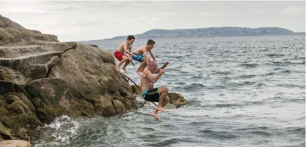  ??  ?? James Russell takes a dip at the 40 Foot in Sandycove with sons Flynn and paddy during a trip home from New Zealand. Photos: Doug O’Connor