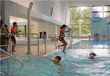  ?? RP-FOTO: CHRISTIAN ALBUSTIN ?? Mit Anlauf ins Wasser springen: Das trauen sich noch nicht alle Kinder, die am Schwimmkur­sus im Büdericher Meerbad teilnehmen.