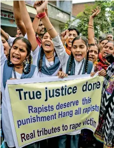  ??  ?? Students hold a banner as they celebrate after police personnel shot dead four detained gang-rape and murder suspects in Shadnagar near Hyderabad, during a gathering in Ahmedabad on Friday. AFP